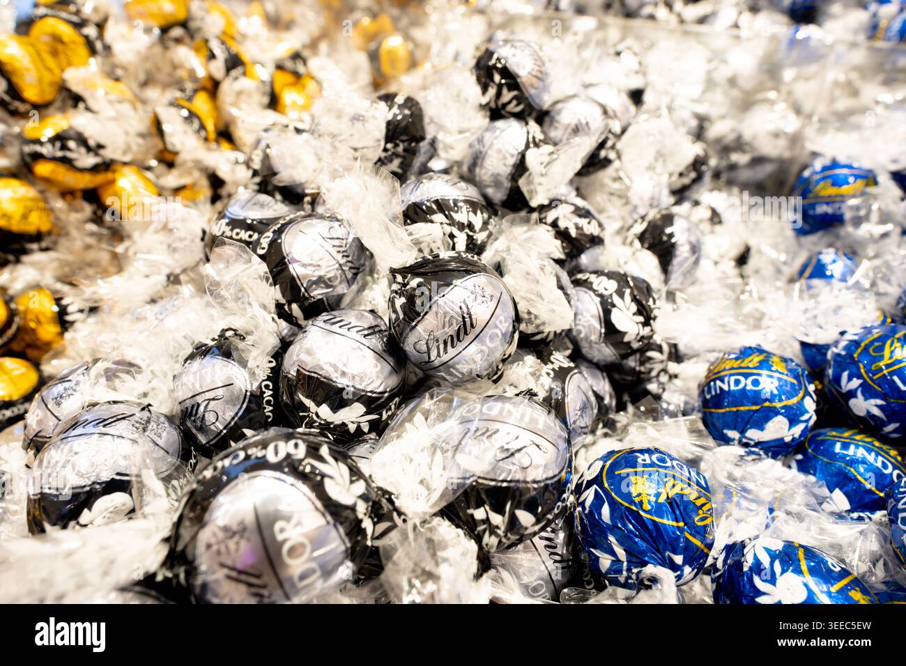 Praline di cioccolato Lindt avvolte in carta colorata in un negozio di caramelle Foto Stock