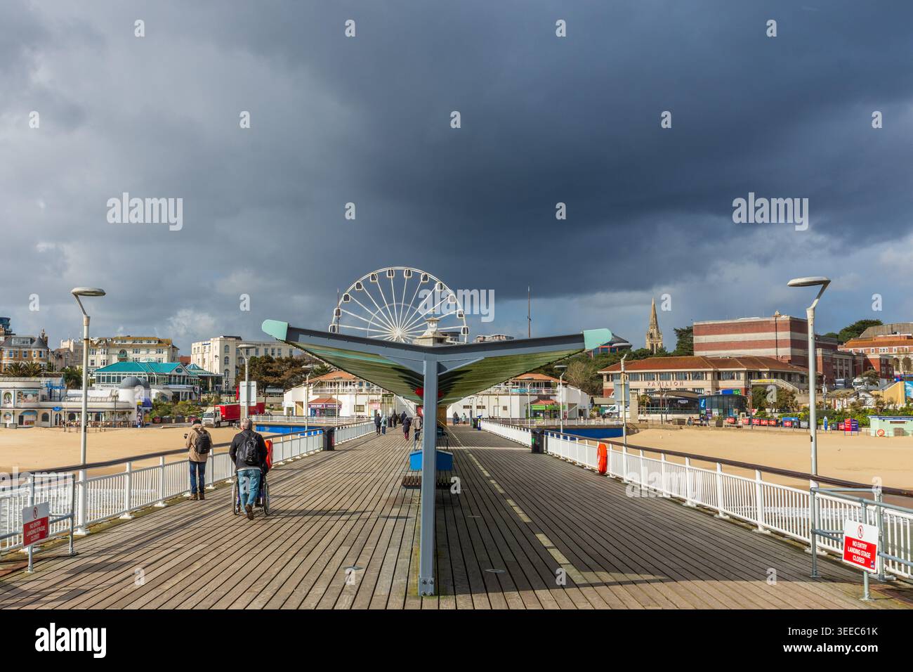 Bournemouth, Regno Unito - 25 marzo 2026: Nuvole scure sopra le persone sulla passeggiata del molo di Bournemouth. Foto Stock