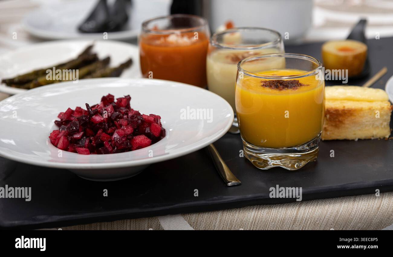 Antipasti assortiti, tra cui insalata di barbabietole, gazpacho e altri piccoli piatti, presentati per la degustazione Foto Stock
