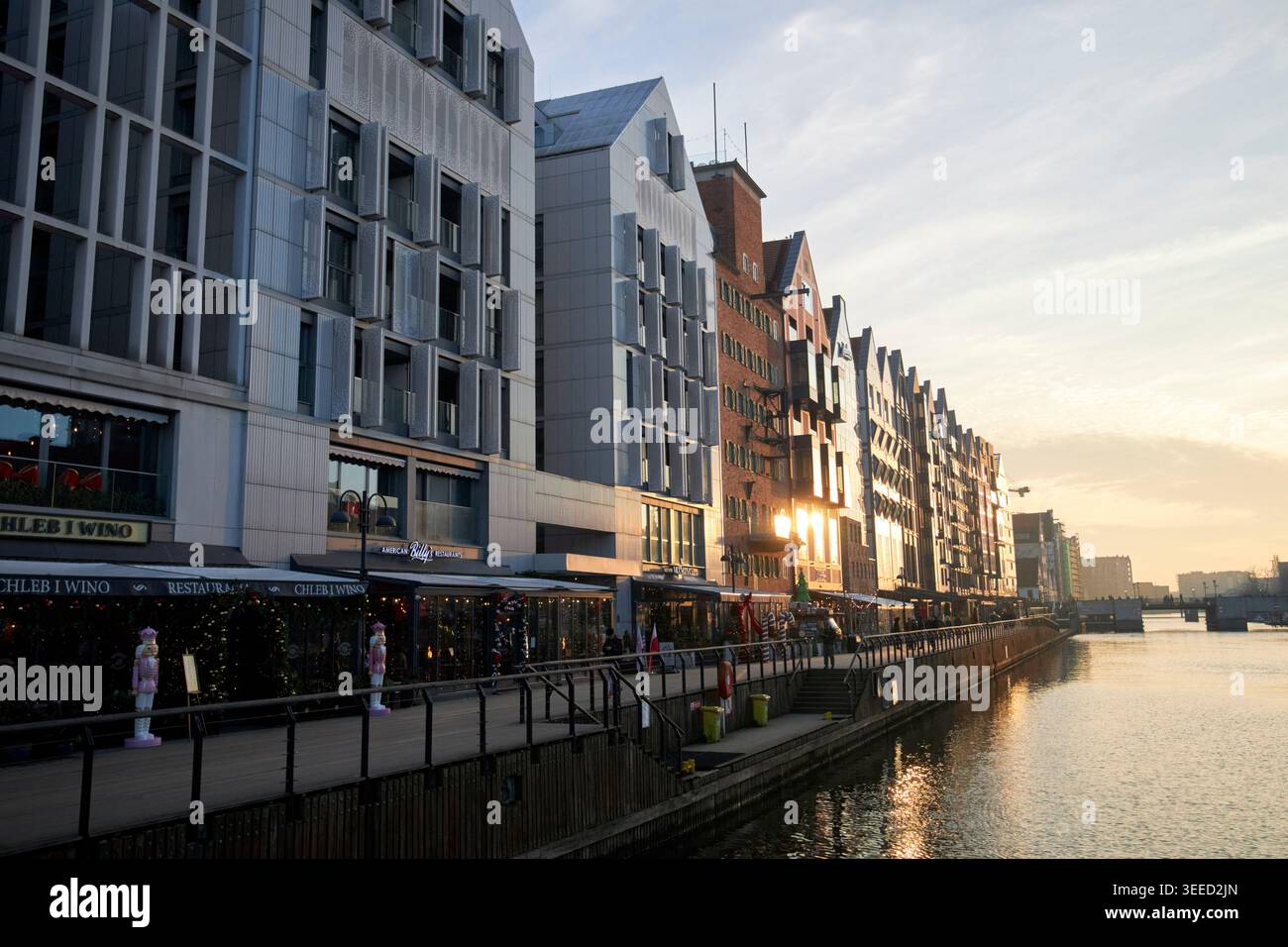 tramonto sugli appartamenti lungo il fiume hotel e ristoranti sull'isola granaria di danzica, polonia Foto Stock