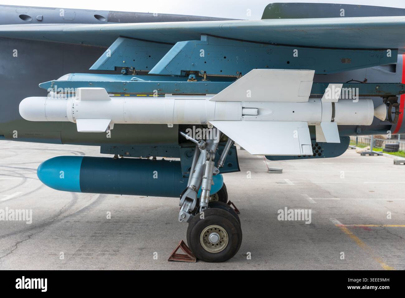Vecchio jet militare con missile vintage e carrello di atterraggio sulla base aerea, sistema d'arma dell'era della Guerra fredda Foto Stock