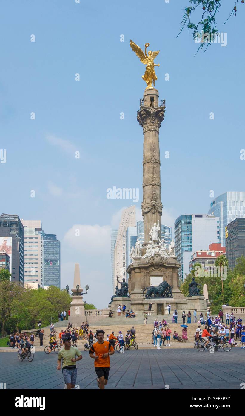 Jogging e ciclisti che passano davanti al monumento dell'Angelo dell'indipendenza durante la domenica senza auto sul Paseo de la Reforma, città del Messico, Messico. Con spazio di copia Foto Stock