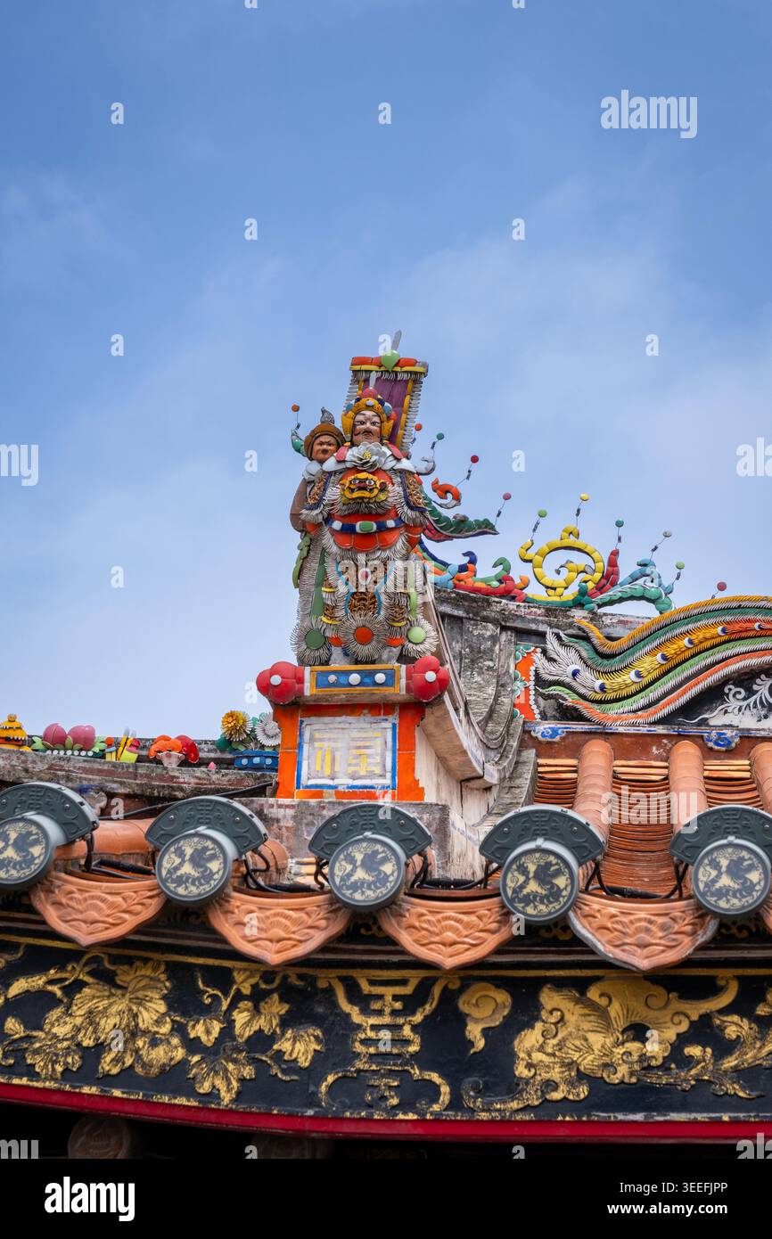 Primo piano del vivace rilievo in porcellana tagliata a Chaozhou che raffigura figure mitologiche e operistiche sul tetto dell'antico tempio di Qinglong, Guangdong, Cina Foto Stock