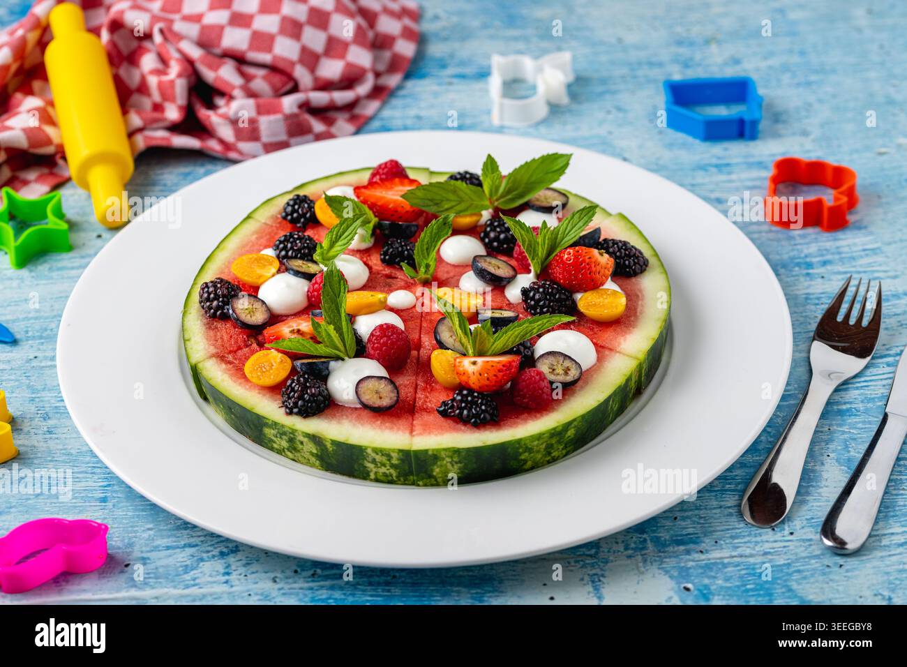 Pizza creativa all'anguria con frutta e frutti di bosco per uno spuntino sano per i bambini Foto Stock
