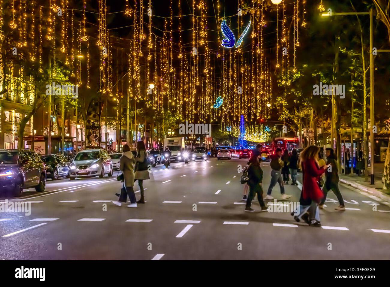Barcellona, Spagna - 26 novembre 2021: Farfalle azzurre e ghirlande dorate sovrastano la strada del Passeig de Gracia a Barcellona di notte Foto Stock