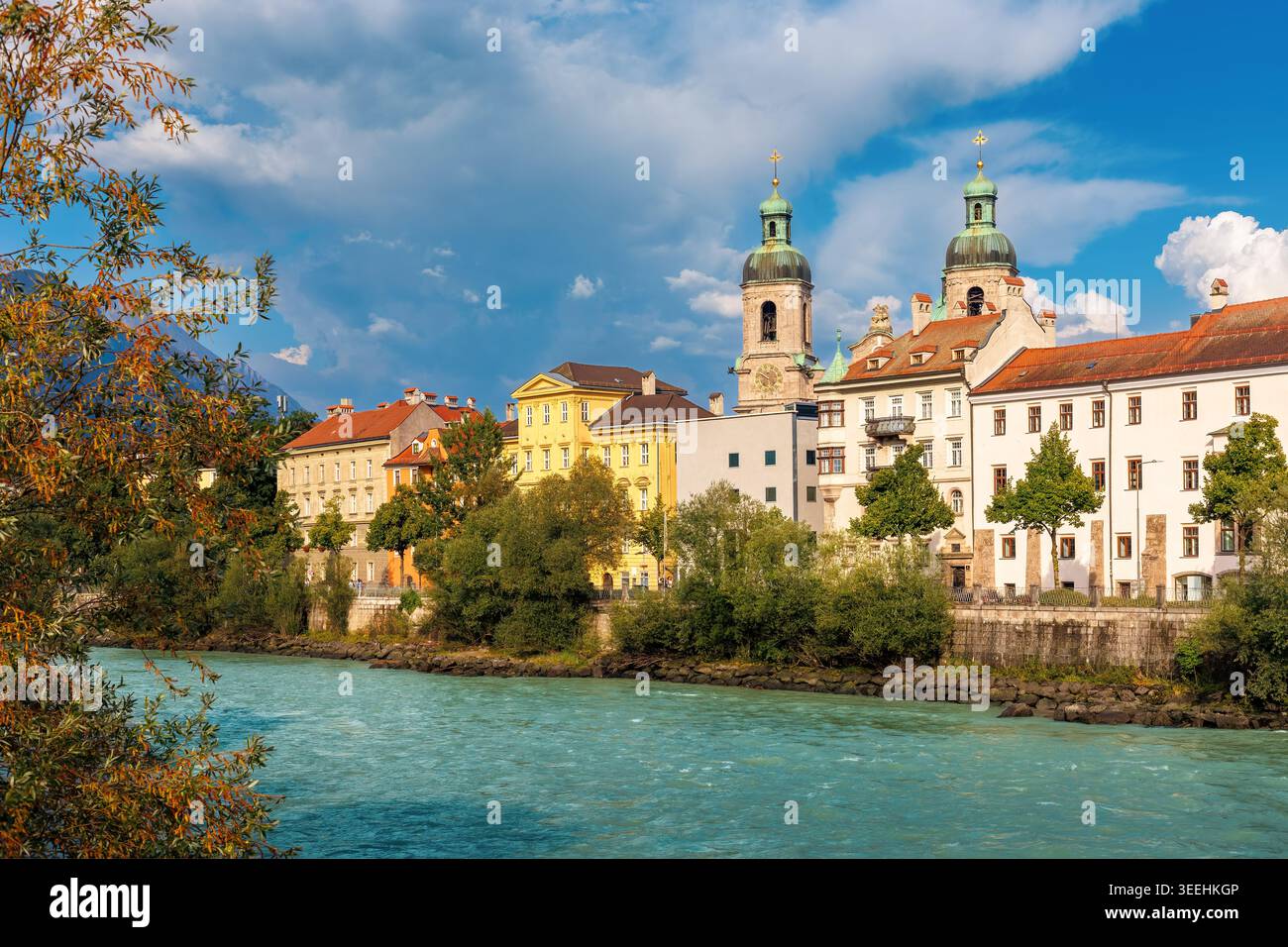 Il fiume Inn scorre oltre le colorate facciate storiche e le torri gemelle della cattedrale di San Giacomo a Innsbruck, Austria Foto Stock