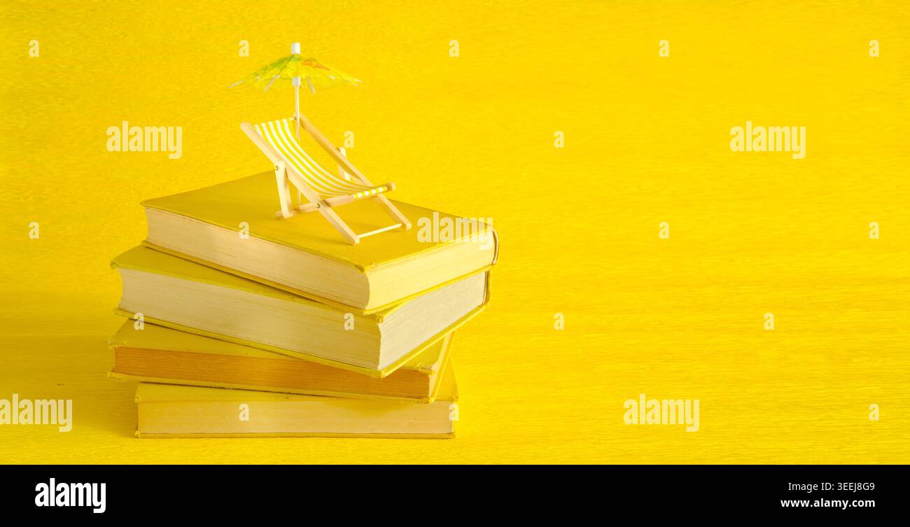 pila di libri con sdraio e ombrellone, leggi le vacanze primaverili e estive. Vacanze,vacanze estive,viaggi, ispirazione,relax con libri,rea Foto Stock