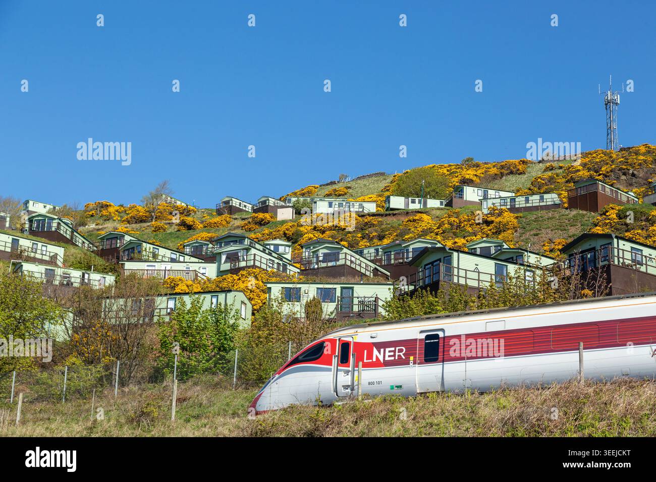 Un treno LNER passa di fronte al Pettycur Bay Holiday Park, Kinghorn, Fife, Scozia Foto Stock