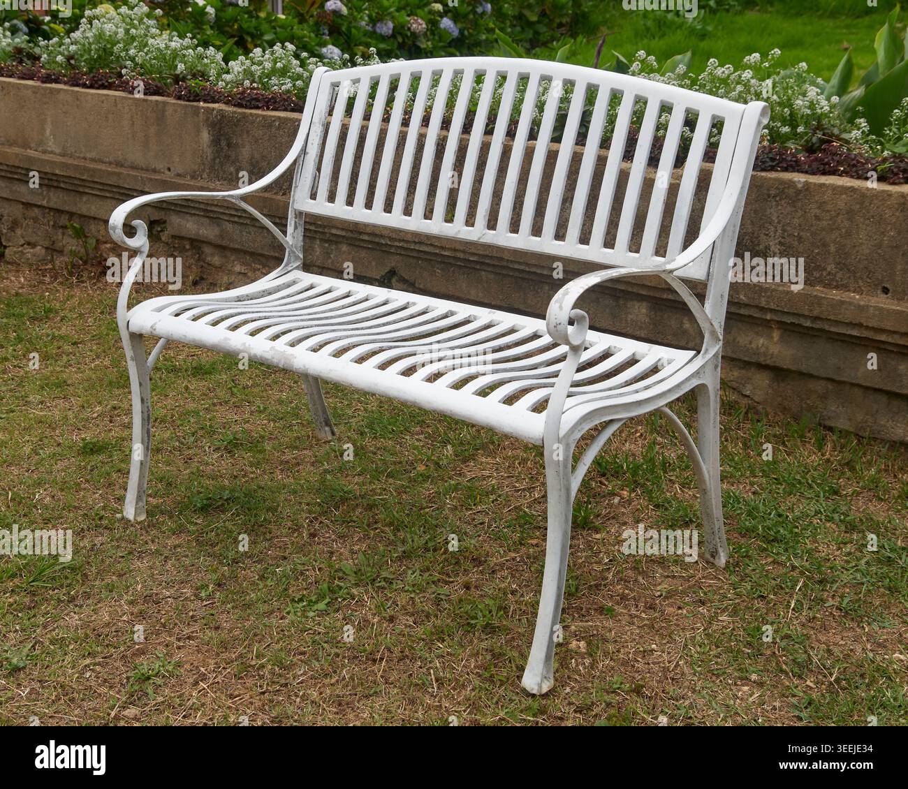 panca da giardino in metallo bianco sull'erba esterna, giardini e relax in giardino con spazio fotocopie Foto Stock