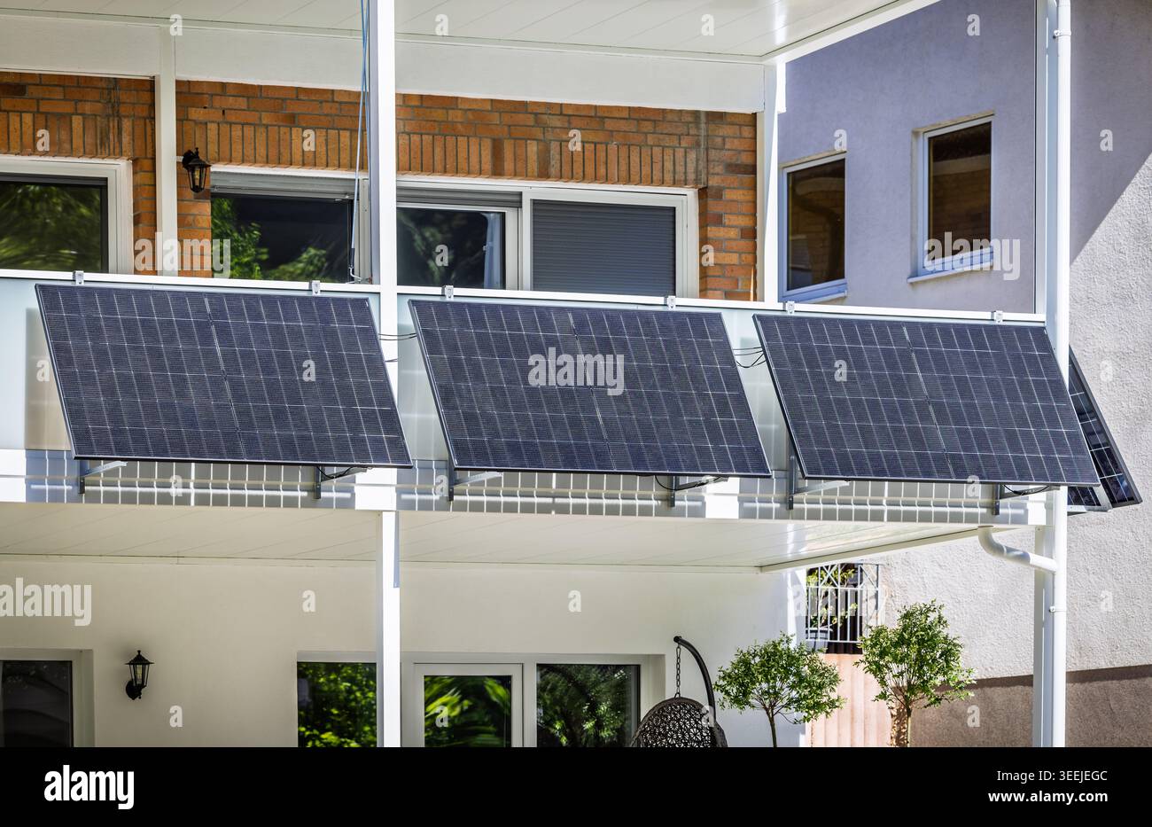 Una centrale elettrica con balcone con pannelli solari montata su una ringhiera di un edificio residenziale Foto Stock