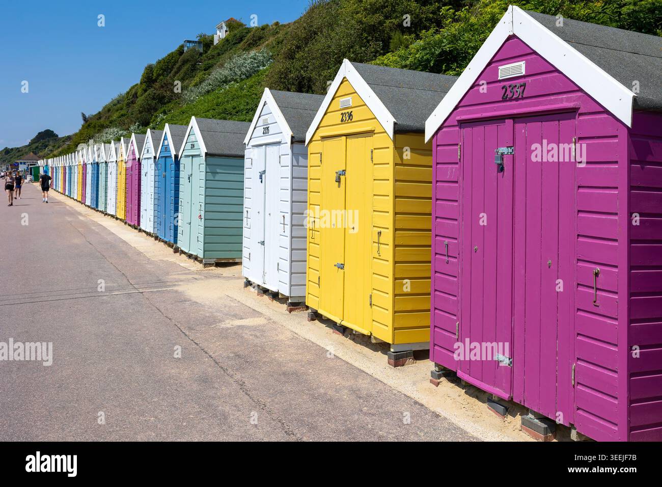 Colorate capanne sulla spiaggia lungo il lungomare di Bournemouth, Dorset, Inghilterra, con una vivace architettura marina sotto i cieli estivi. Foto Stock