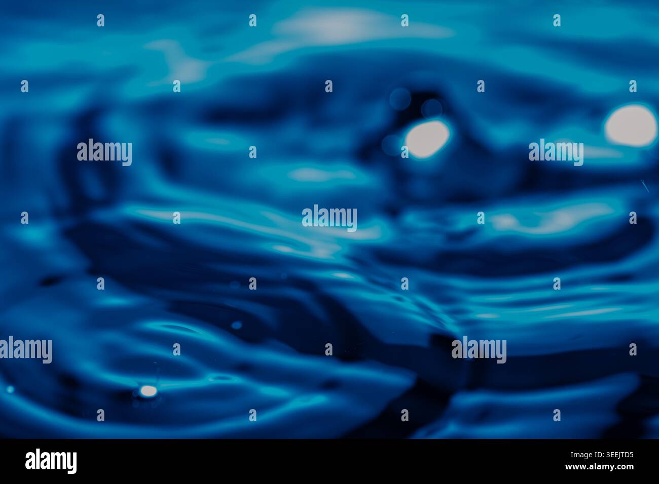 274.primo piano della superficie dell'acqua che mostra motivi ondulati e riflessi di luce. I toni blu dominanti con evidenziazioni bianche creano un testo astratto dinamico Foto Stock