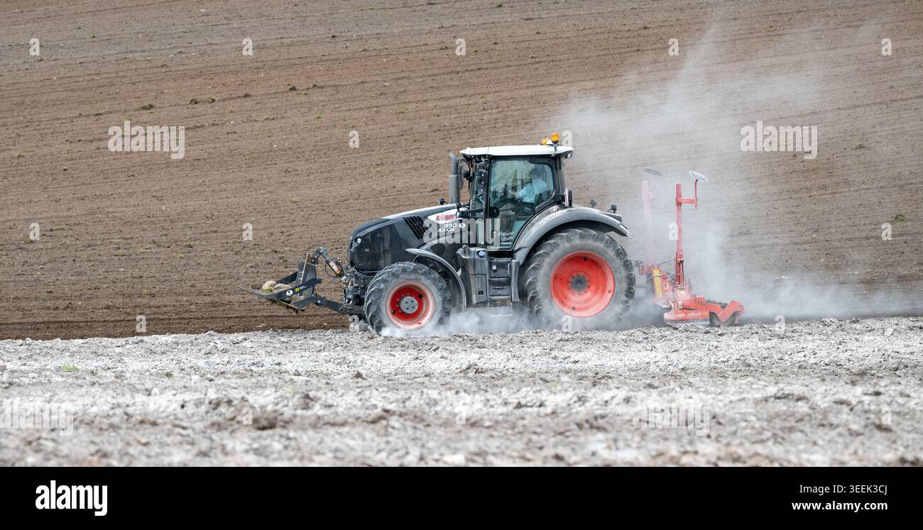 Claas Axion 830 eruttante di potenza in calce appena sparsa su un campo arato. Il calcare in polvere aiuta la fertilità del terreno. Cumbria, Regno Unito. Foto Stock