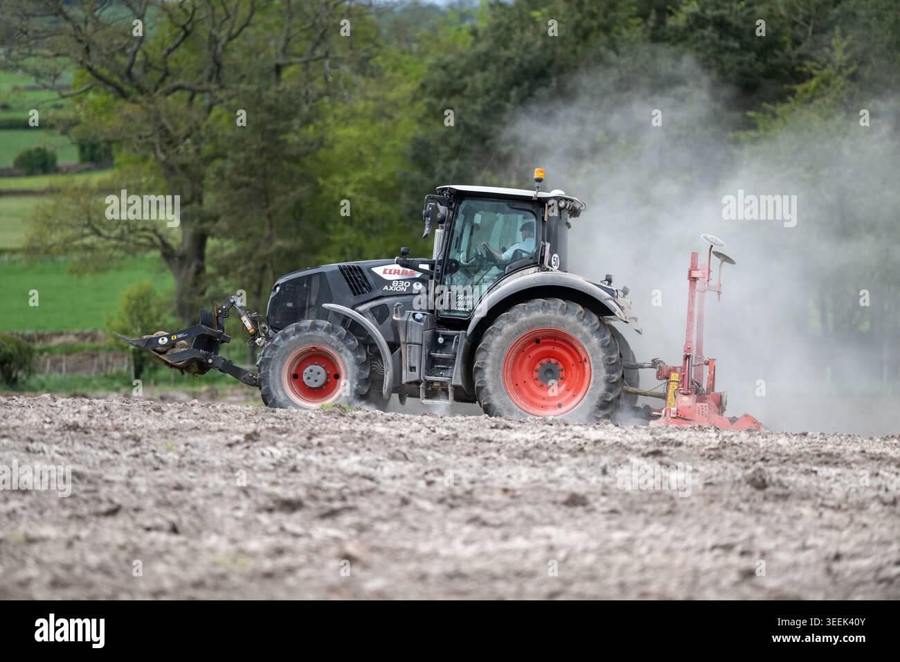 Claas Axion 830 eruttante di potenza in calce appena sparsa su un campo arato. Il calcare in polvere aiuta la fertilità del terreno. Cumbria, Regno Unito. Foto Stock