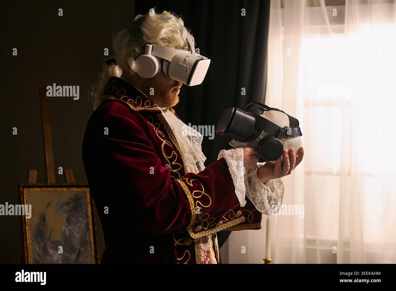 Uomo che indossa un costume storico e utilizza un visore per la realtà virtuale tenendo in mano un secondo dispositivo, illustrando il contrasto dell'innovazione. Per marketing tecnologico o campagne future Foto Stock