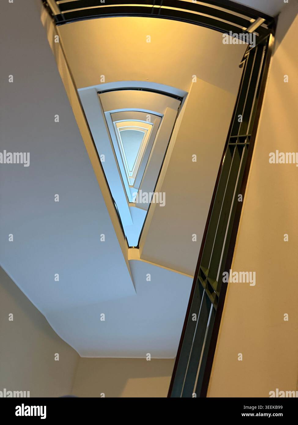 una vertiginosa prospettiva ad angolo basso che guarda direttamente al centro di una scala triangolare Foto Stock