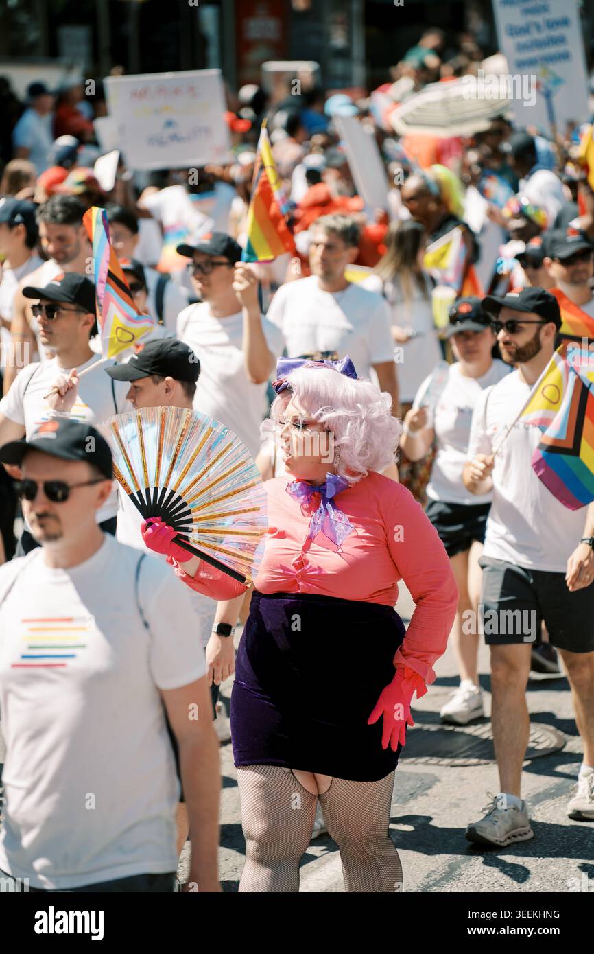 Toronto, Canada - 29 giugno 2025: Drag performer in parrucca rosa che porta una folla diversificata Foto Stock