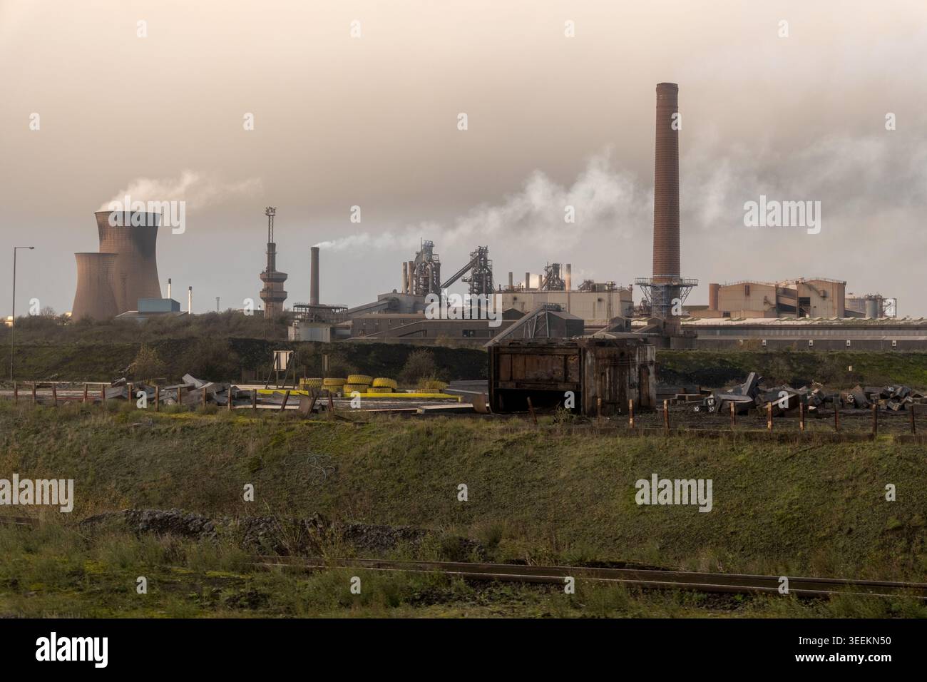 Skyline industriale all'interno delle acciaierie Scunthorpe con altiforni, torri di raffreddamento e camini fumanti sotto nuvole grigie inquinate, Inghilterra, Regno Unito. Foto Stock