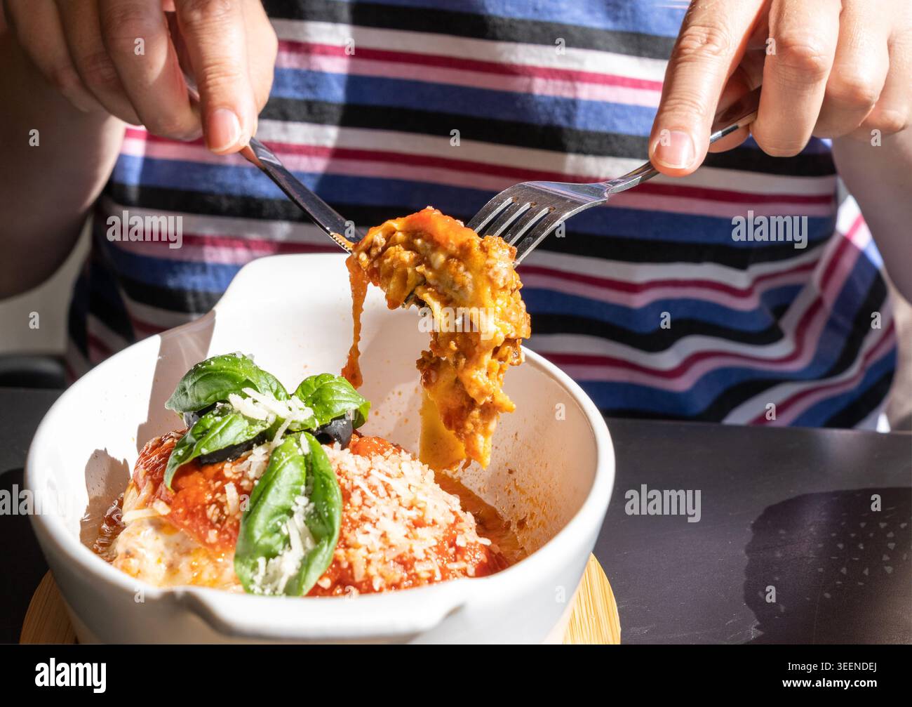 Lasagne, lasagne al forno, strati di pasta con formaggio, carne macinata, pomodoro. Lasagne sul tavolo del ristorante in strada in un giorno d'estate soleggiato, sfocate Foto Stock