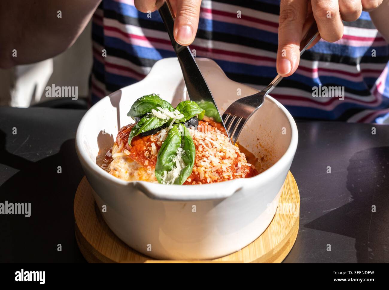 Lasagne, lasagne al forno, strati di pasta con formaggio, carne macinata, pomodoro. Lasagne sul tavolo del ristorante in strada in un giorno d'estate soleggiato, sfocate Foto Stock