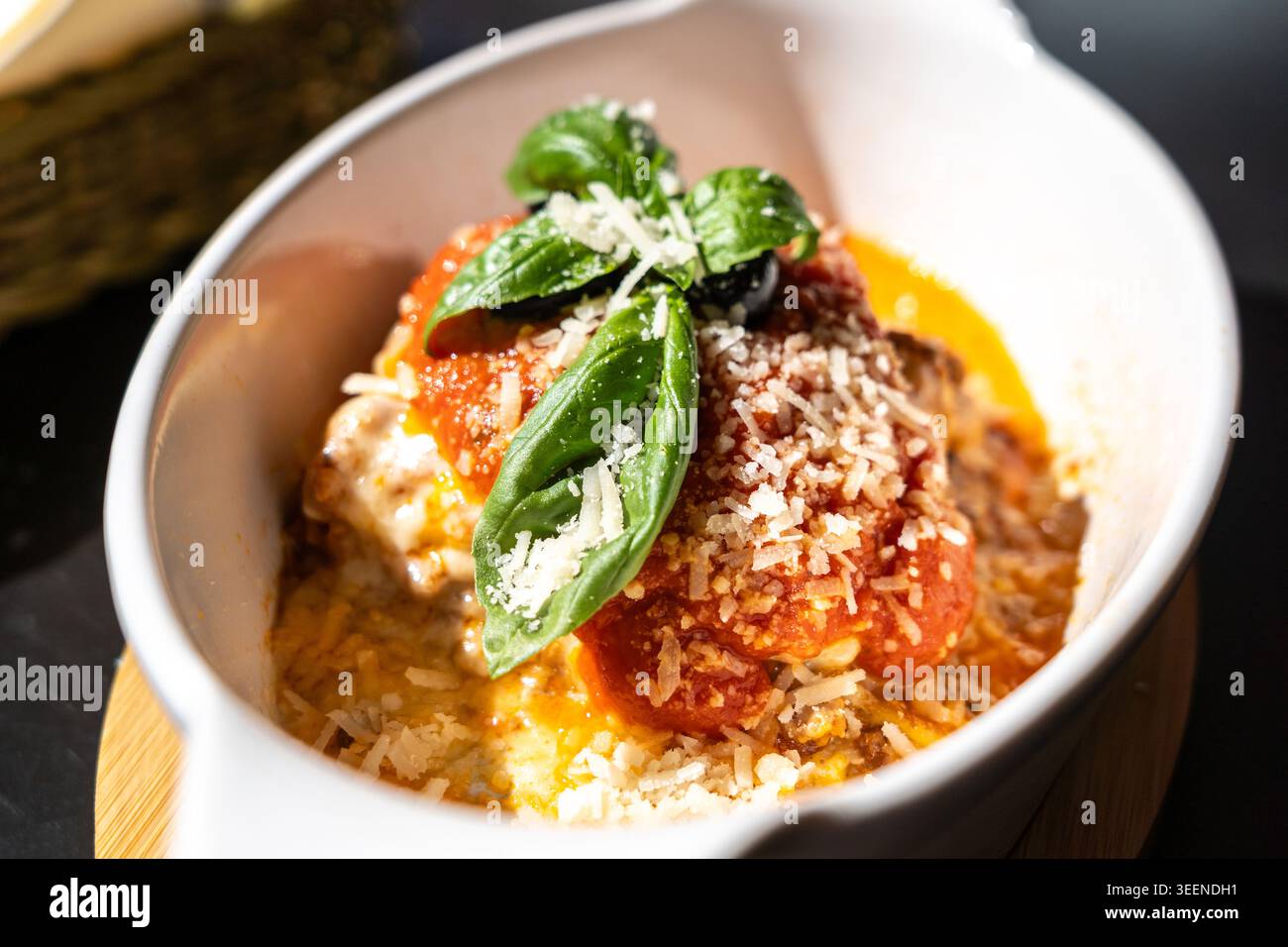 Lasagne, lasagne al forno, strati di pasta con formaggio, carne macinata, pomodoro. Lasagne sul tavolo del ristorante in strada in un giorno d'estate soleggiato, sfocate Foto Stock