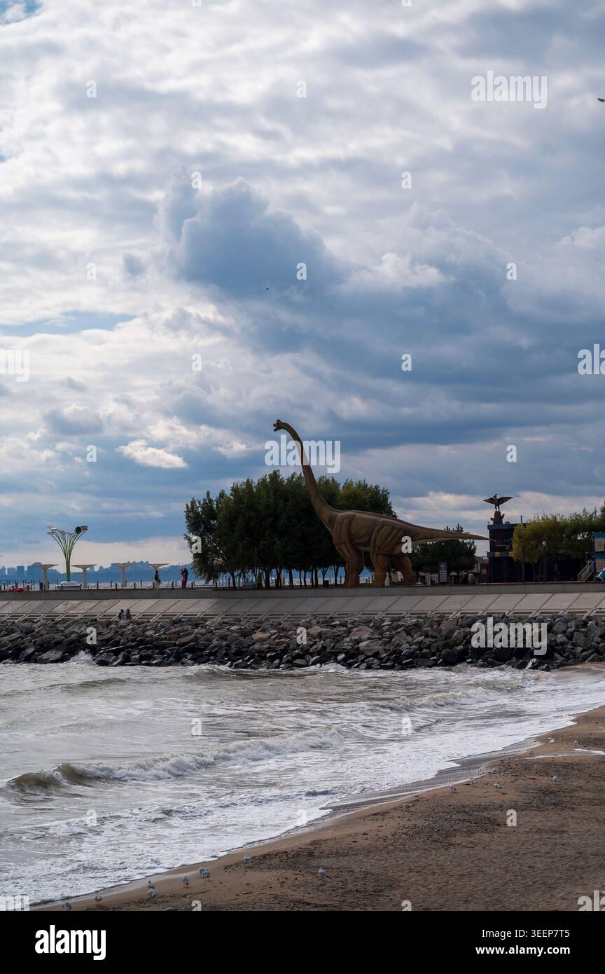 Vista panoramica di un parco di dinosauri situato sulla riva sotto un cielo blu. Concetto di pianificazione delle destinazioni di vacanza, servizi del resort e uscite educative Foto Stock