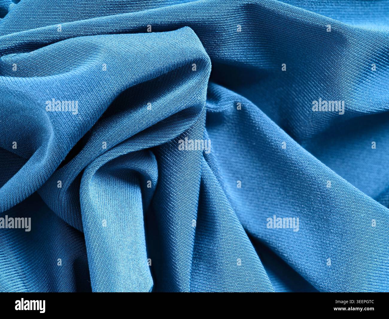 Tessuto in maglia blu con pieghe e increspature morbide per creare uno sfondo astratto e rilassante Foto Stock