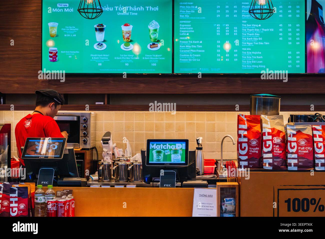 Banco caffè moderno con barista e menu digitali presso l'Highlands Coffee Foto Stock