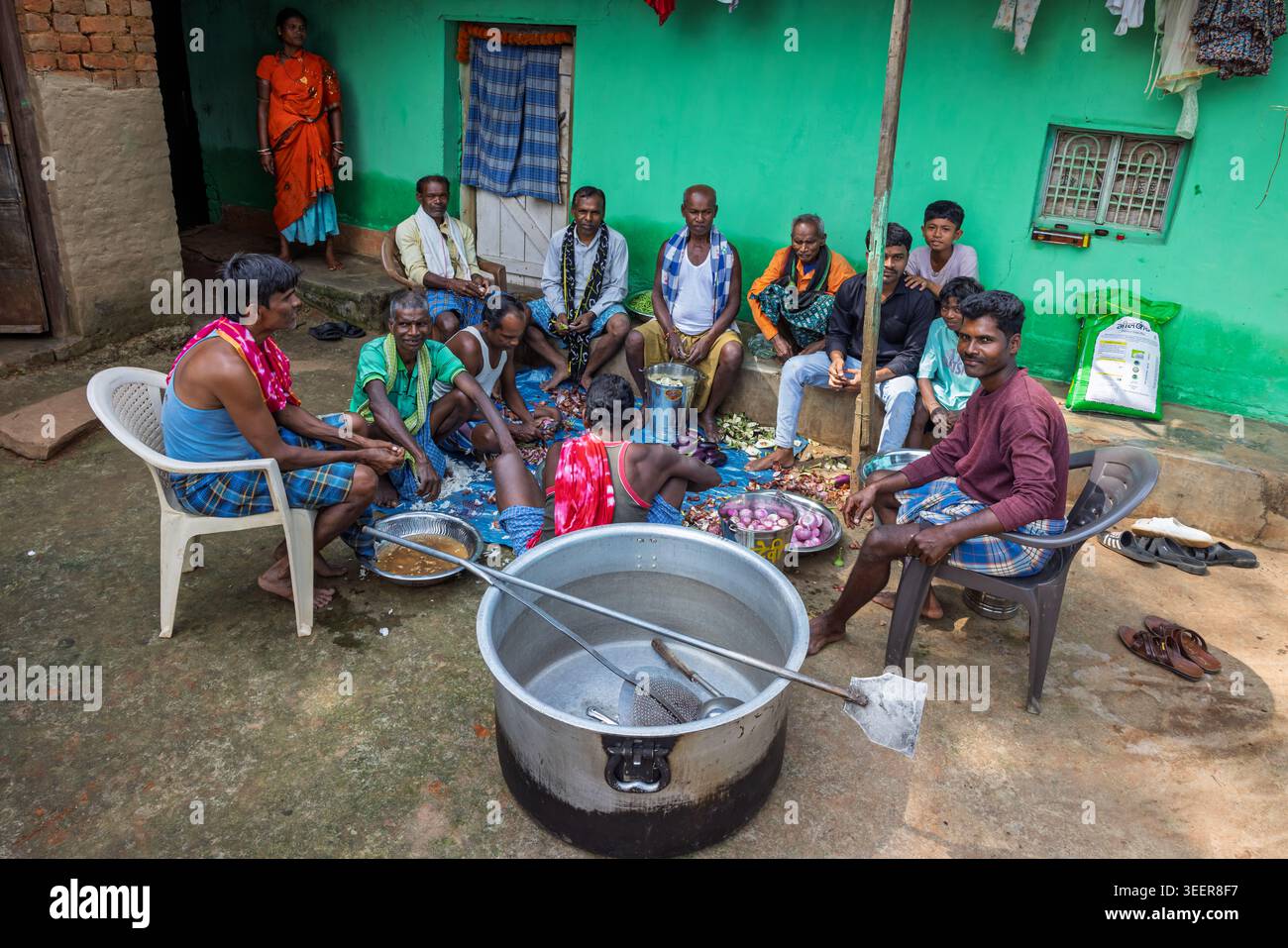 Uomini del villaggio che preparano il cibo in un cortile per un funerale, Orissa, India Foto Stock