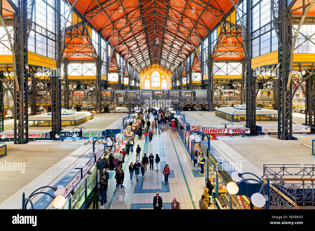 Le persone camminano attraverso il mercato centrale di Budapest in Ungheria. Le bancarelle espongono varie merci e il mercato è occupato di attività. Foto Stock