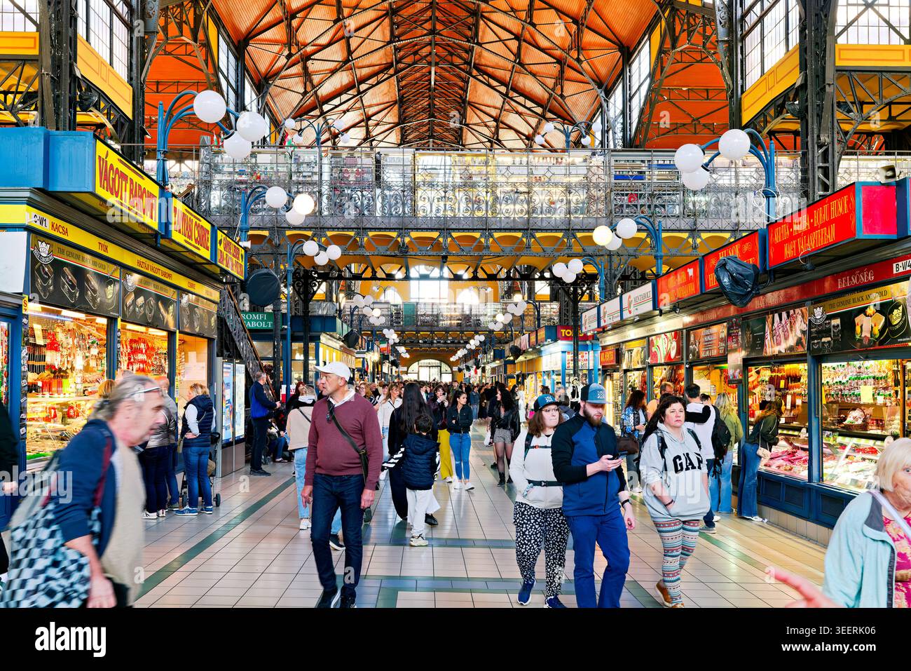 Le persone camminano attraverso il mercato centrale di Budapest. Le bancarelle espongono vari cibi e merci. Il mercato è frequentato da acquirenti e visitatori. Foto Stock