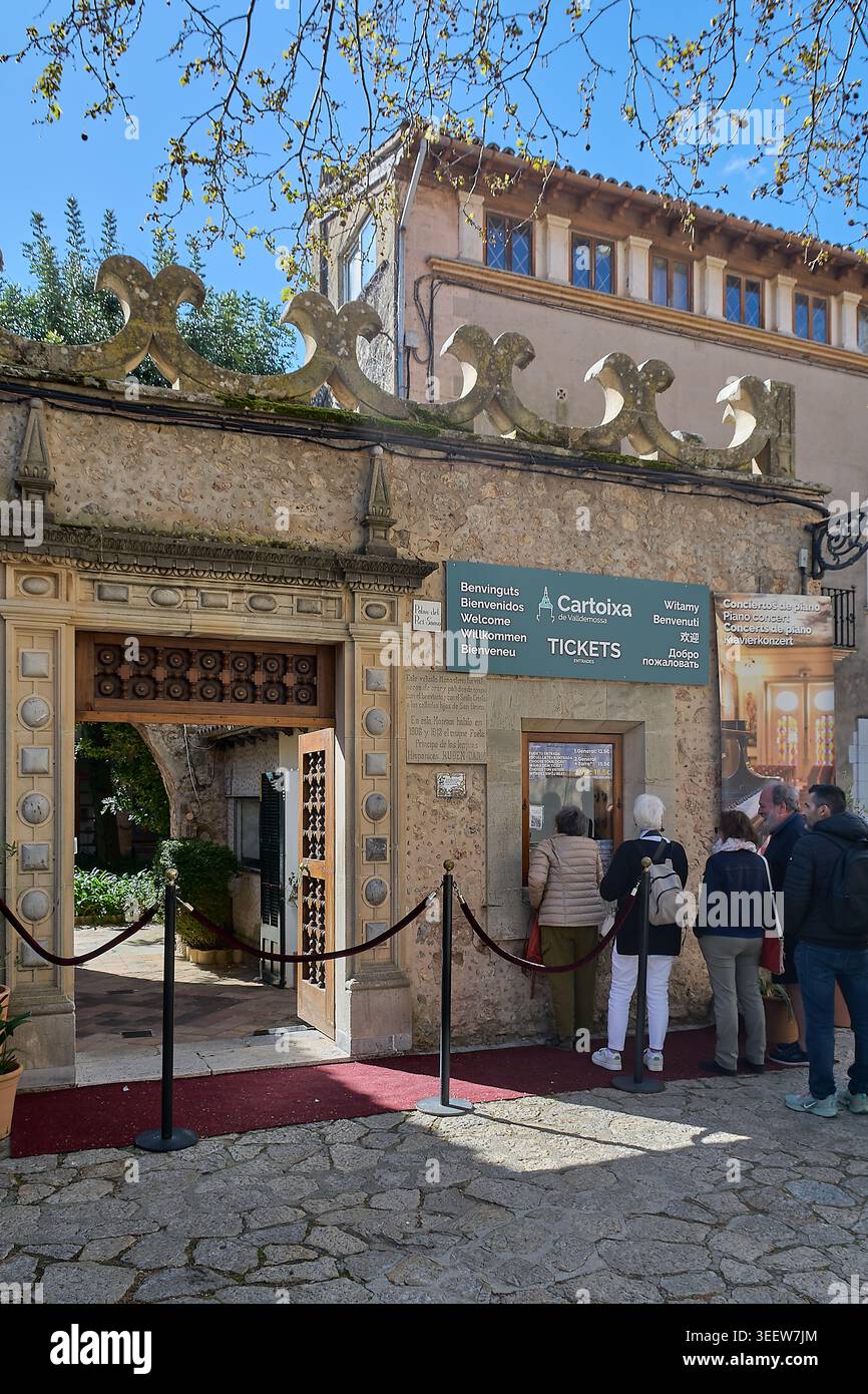 Maiorca, Spagna - 12 maggio 2026: I turisti aspettano in fila presso la biglietteria storica in pietra del monastero di Cartuja de Valldemossa per acquistare l'ingresso Foto Stock