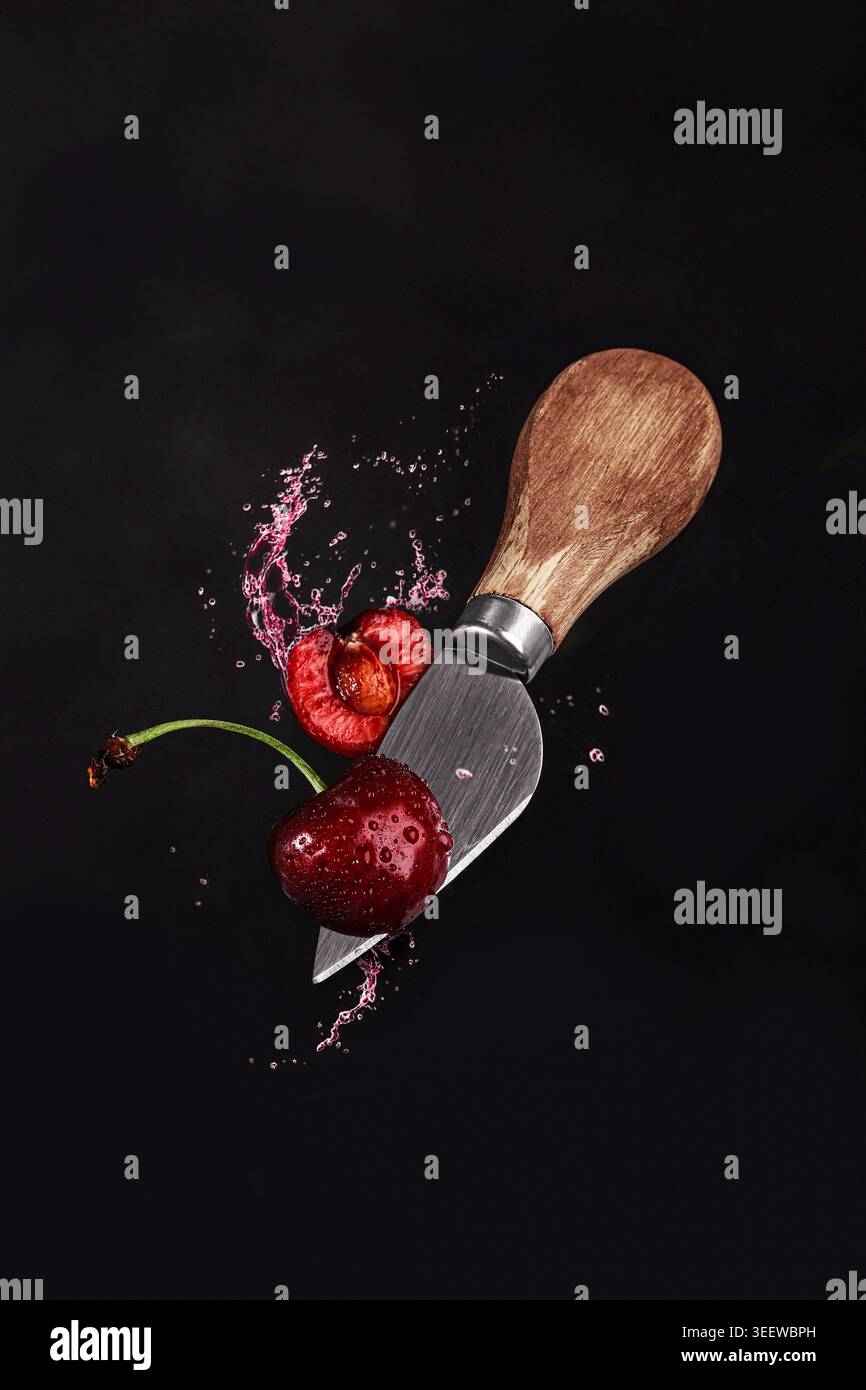 Scatto ad alta velocità per catturare la ciliegia affettata e il succo di frutta Foto Stock