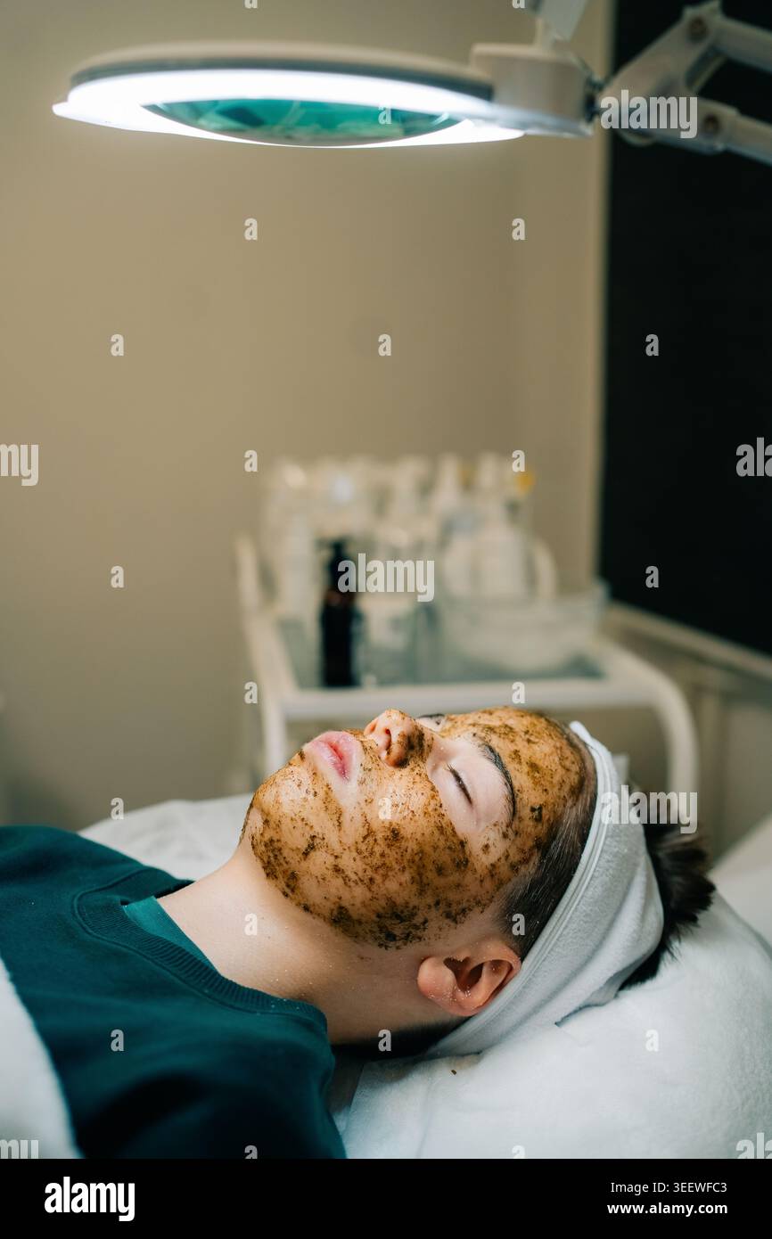 Teen riceve acne trattamento maschera sessione per una pelle più chiara Foto Stock