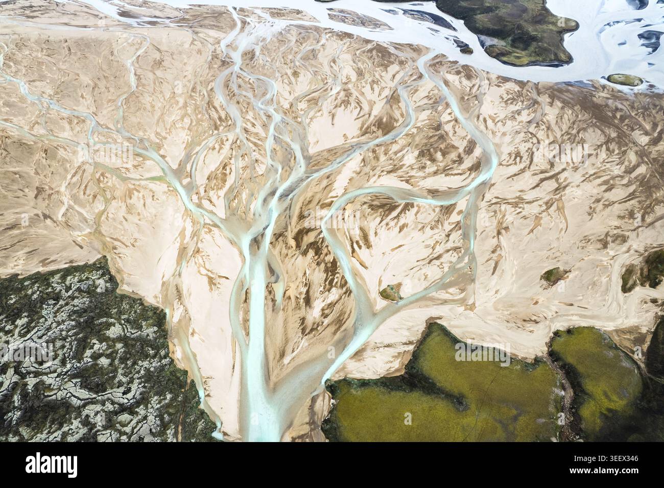 Vista aerea degli intricati intrecciati modelli di fiume glaciale della zona stradale F208 con acqua turchese che scorre attraverso sabbia vulcanica e muschio verde IC Foto Stock