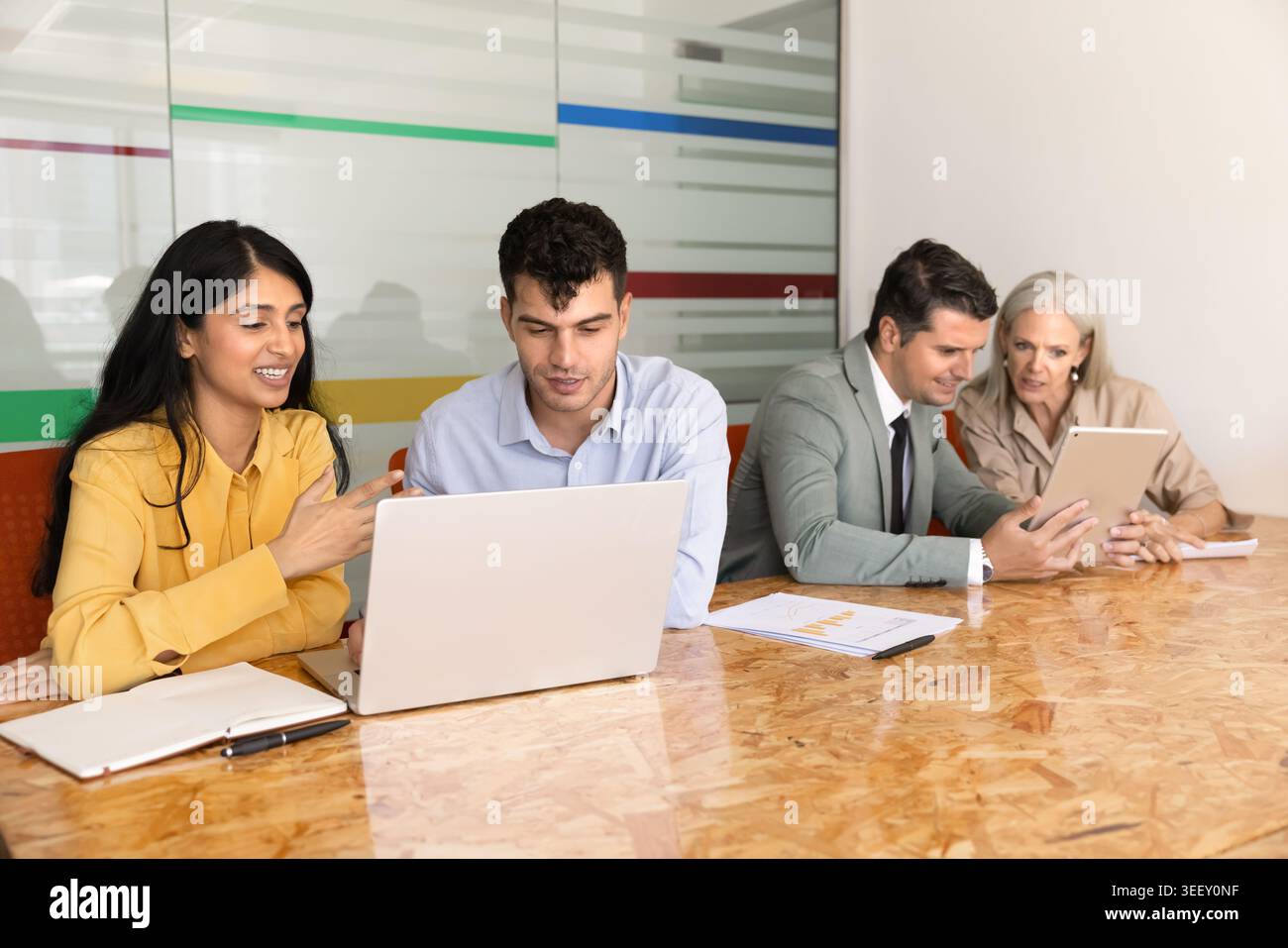 Diversi professionisti aziendali che collaborano con notebook in ufficio Foto Stock