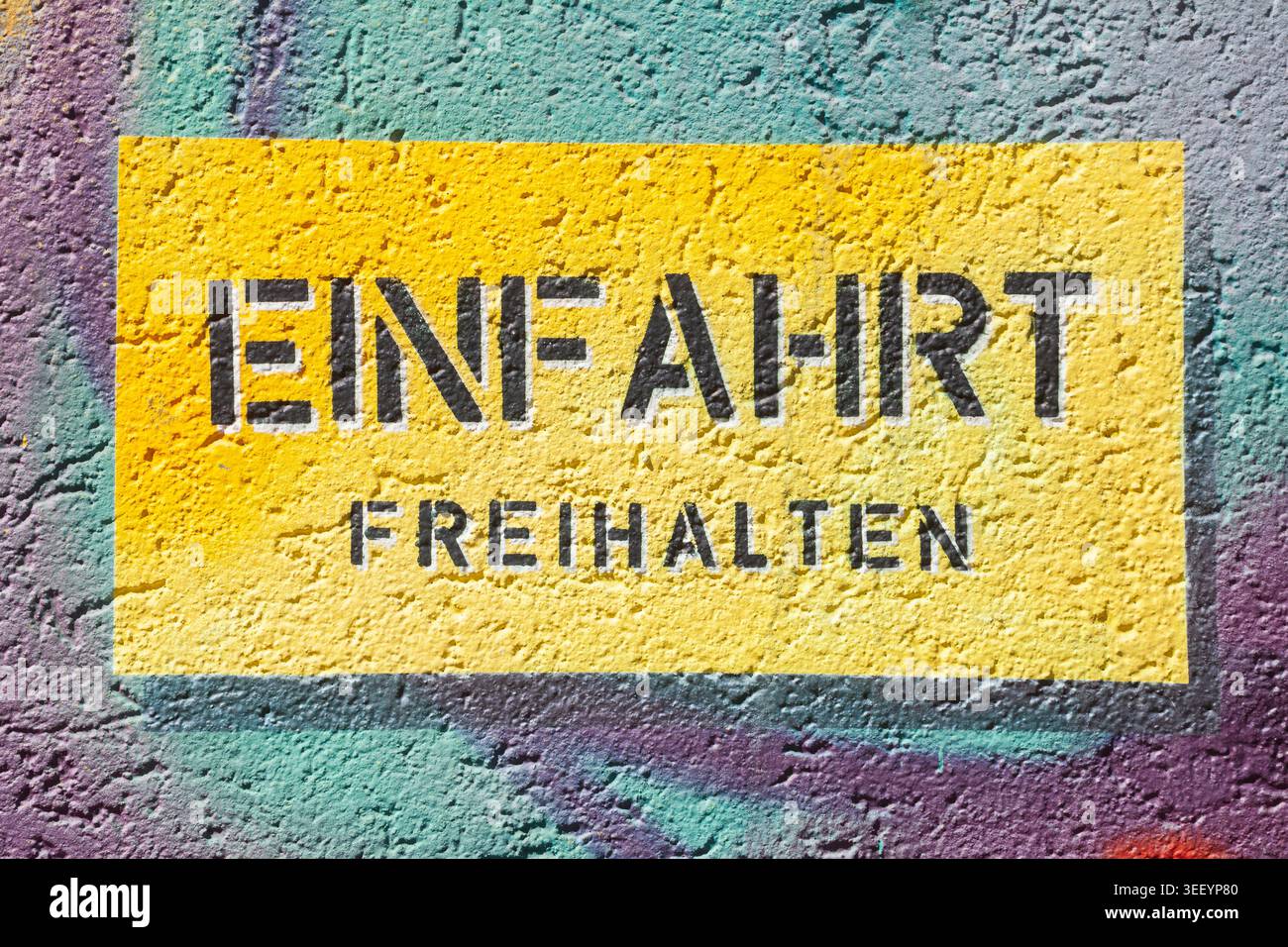 Gelbes Schild Einfahrt freihalten un einer bunt bemalten Mauer, Deutschland Foto Stock