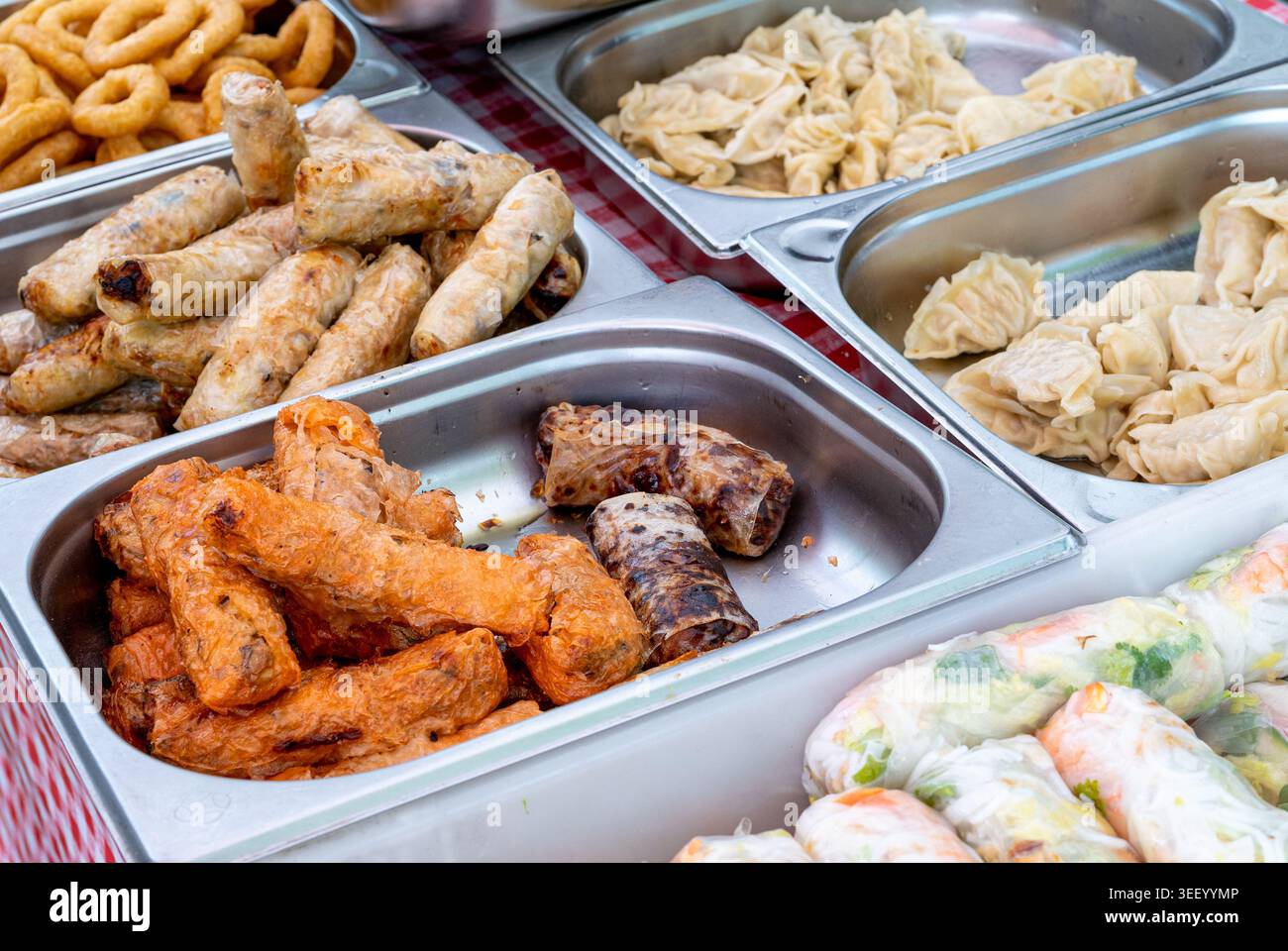 Involtini primavera, noti anche come involtini d'uovo, involtini estivi, lumpia o nom, serviti in vassoi, evidenziando elementi croccanti, freschi e salati, perfetti per l'app Foto Stock