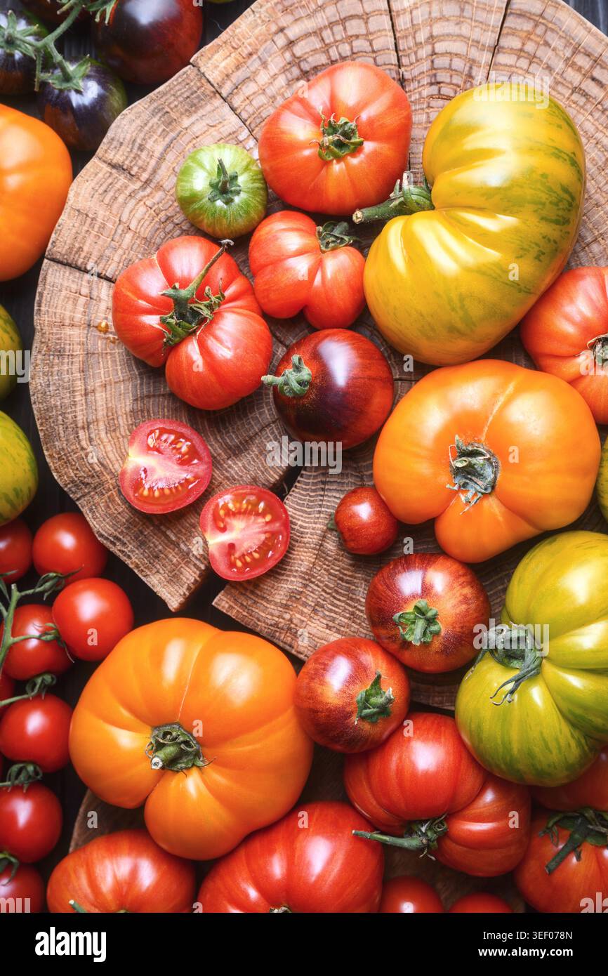 Chiudere la stesa piatta di pomodori colorati che riempiono la cornice. Prodotti agricoli biologici consistenza, sfondo alimentare vivace Foto Stock