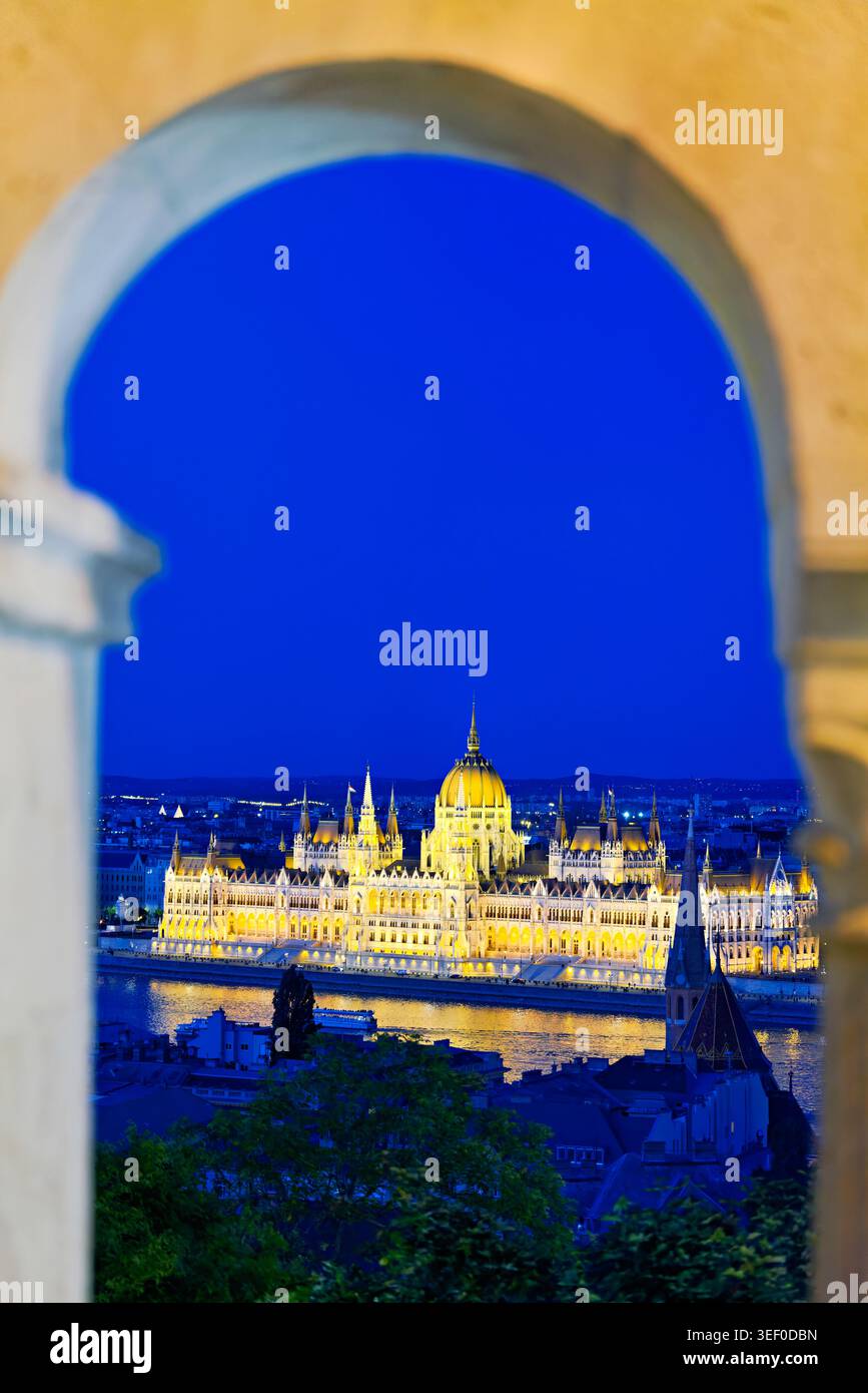 Budapest al tramonto, che mette in evidenza l'edificio del Parlamento sul Danubio, con le luci della città che iniziano a brillare. Foto Stock