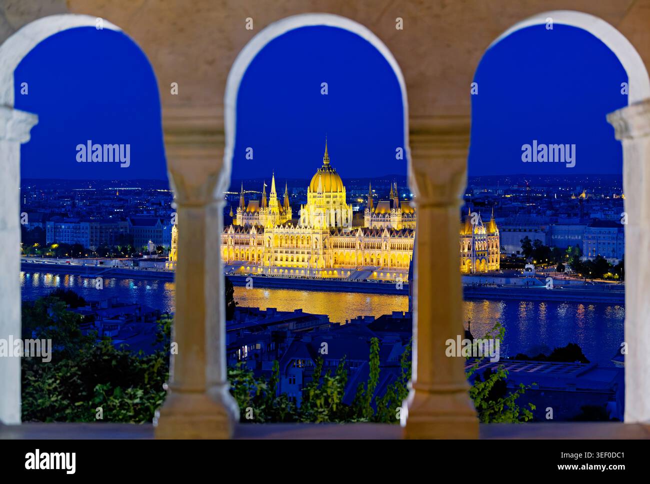 La scena mostra una vista aerea di Budapest. L'edificio del Parlamento si trova vicino al Danubio mentre il sole tramonta sulla città. Foto Stock