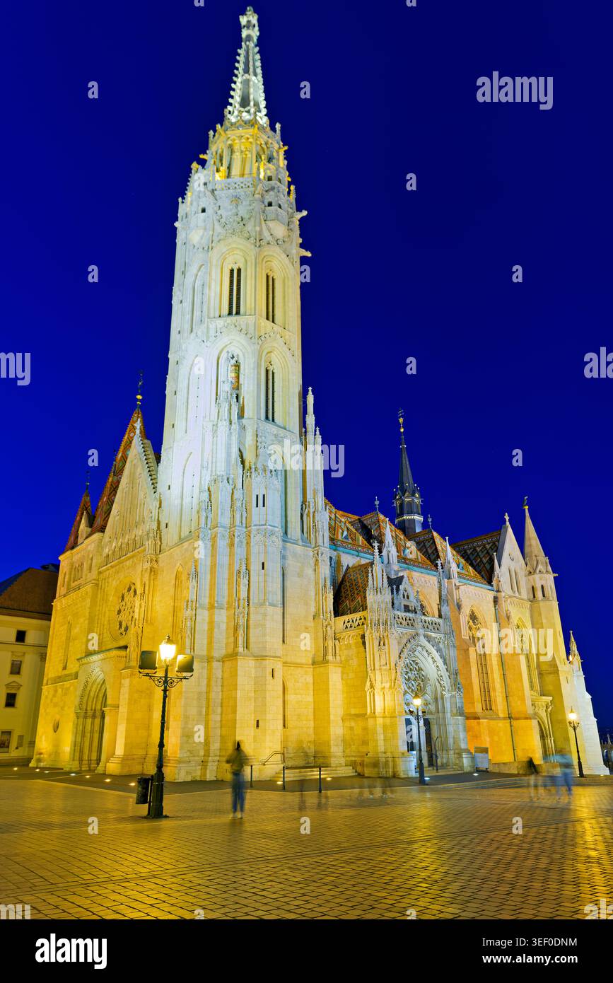 La chiesa di Mattia si erge a Budapest mentre il sole tramonta, proiettando un caldo bagliore sulla struttura e sull'area circostante. Foto Stock