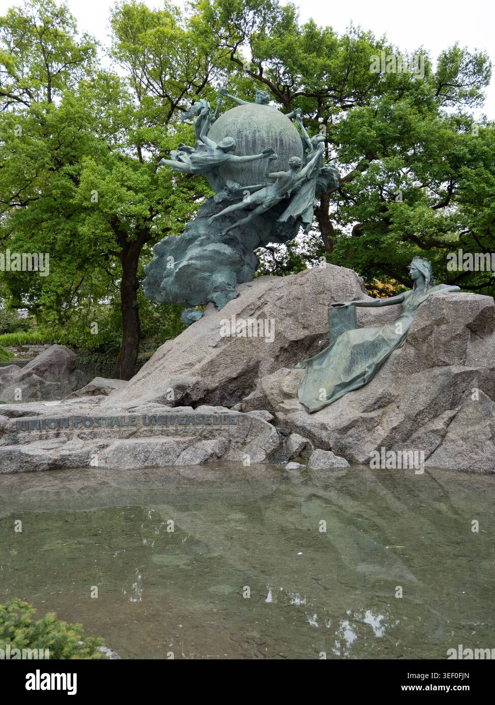 Weltpostdenkmal - globo allegorico in bronzo e figura sdraiata sul basamento roccioso nel parco di Berna Foto Stock