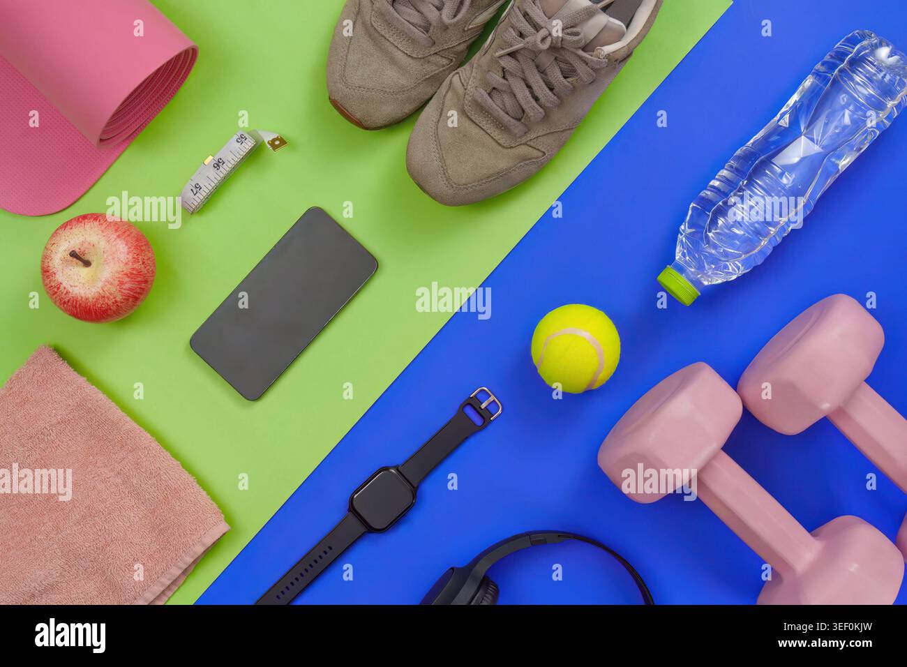 Gli indispensabili per l'allenamento fitness sono piatti con manubri, tappetino per yoga e dispositivi intelligenti Foto Stock