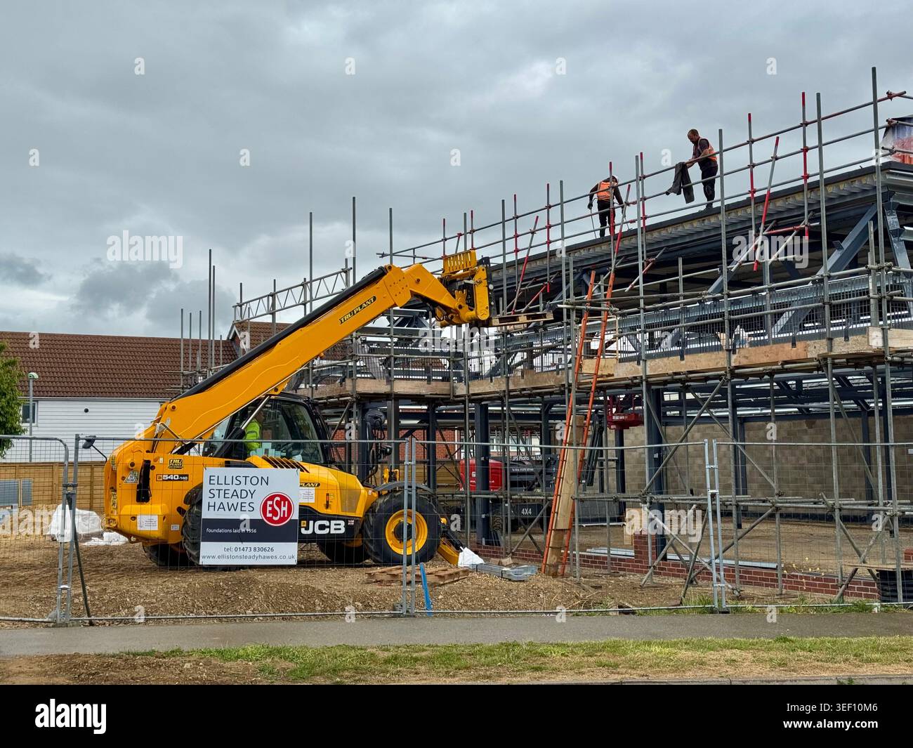 Kesgrave, Suffolk - 13 maggio 2026 : JCB lavora sul tetto. Foto Stock