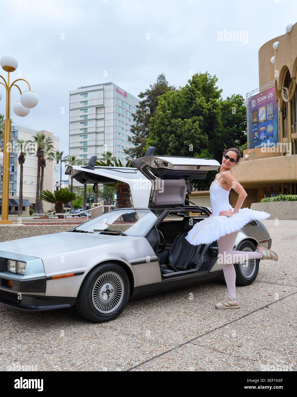 Ballerina in posa accanto all'iconica auto sportiva DeLorean a San Jose, 5 maggio 2026 Foto Stock