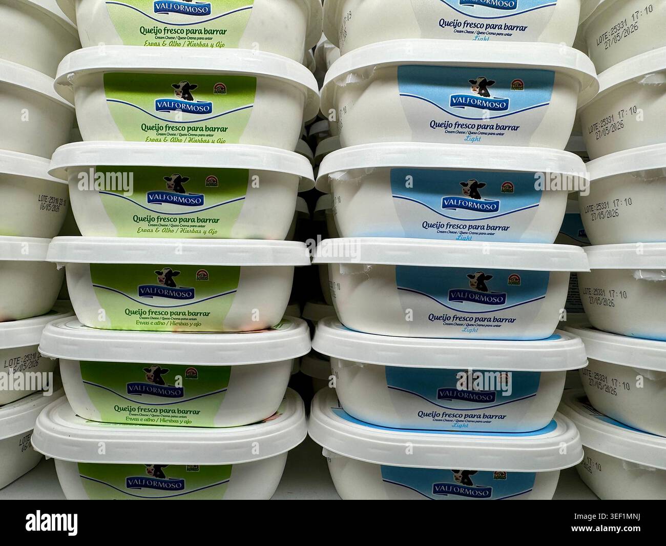 Pile di vasche in plastica con formaggio fresco spalmabile del marchio Valformoso su uno scaffale del supermercato, che presentano due varietà: Erbe, aglio e leggero. - Immagine stock catturata con smartphone