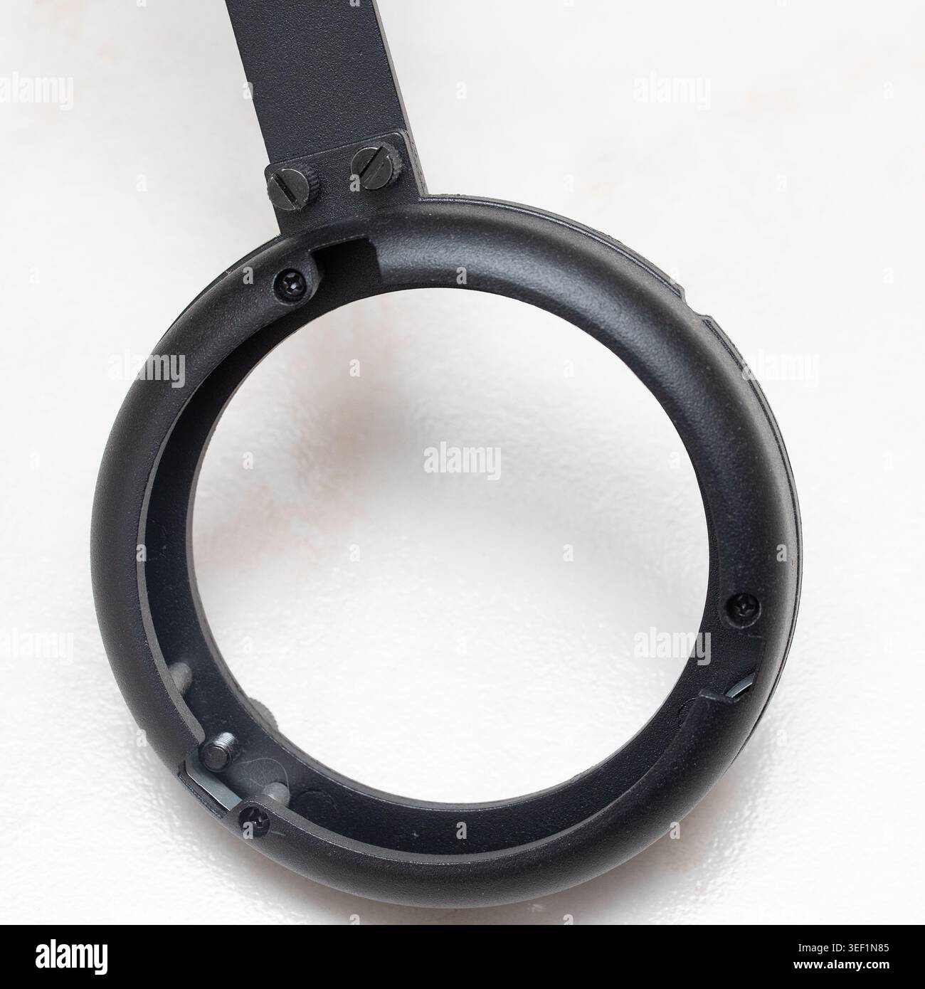 Componente ad anello in plastica nero che mostra i fori delle viti interne e i dettagli della bulloneria di montaggio Foto Stock