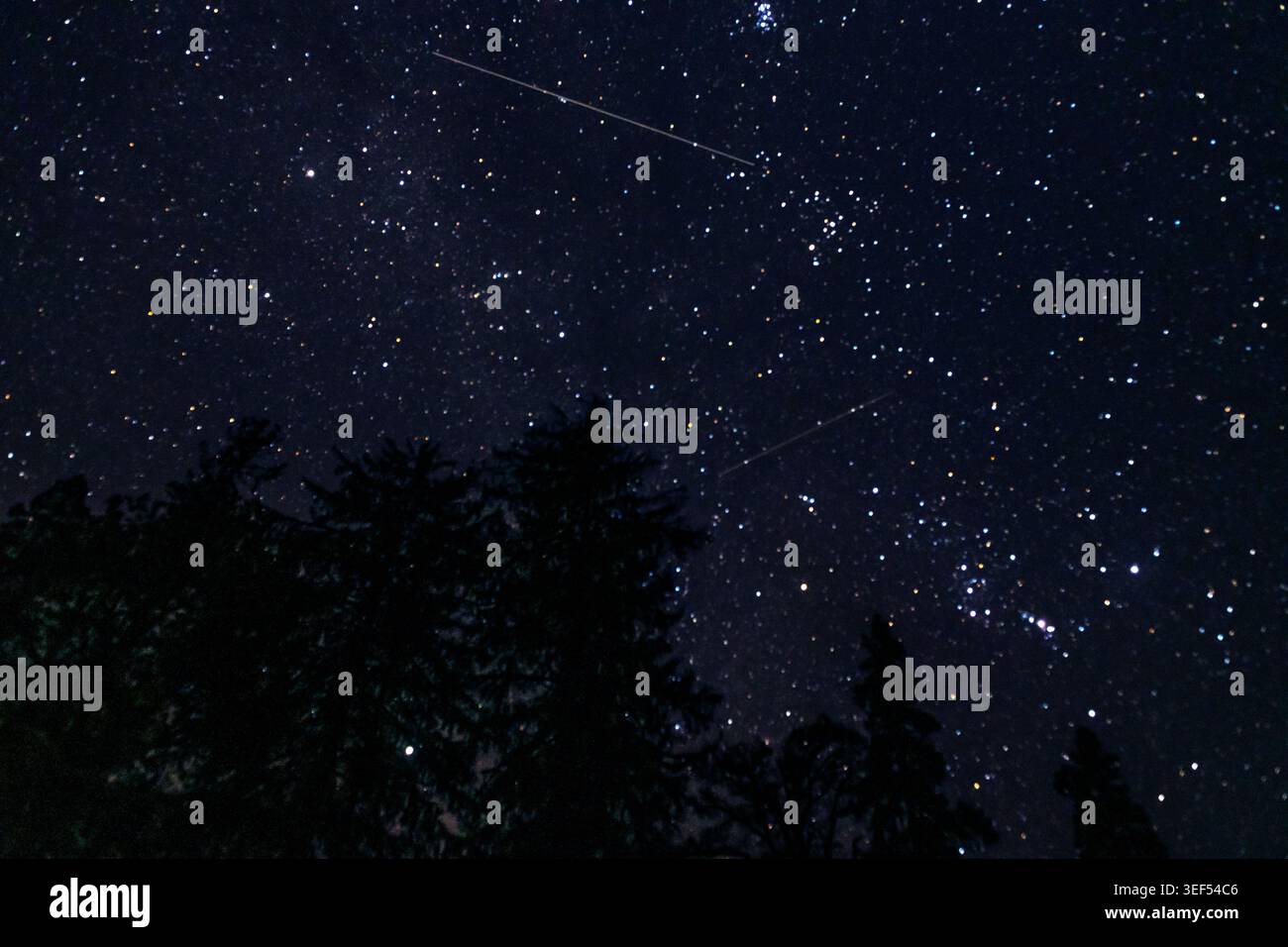 Meteorite perseide in costellazioni stellari provenienti da una campagna oscura Foto Stock