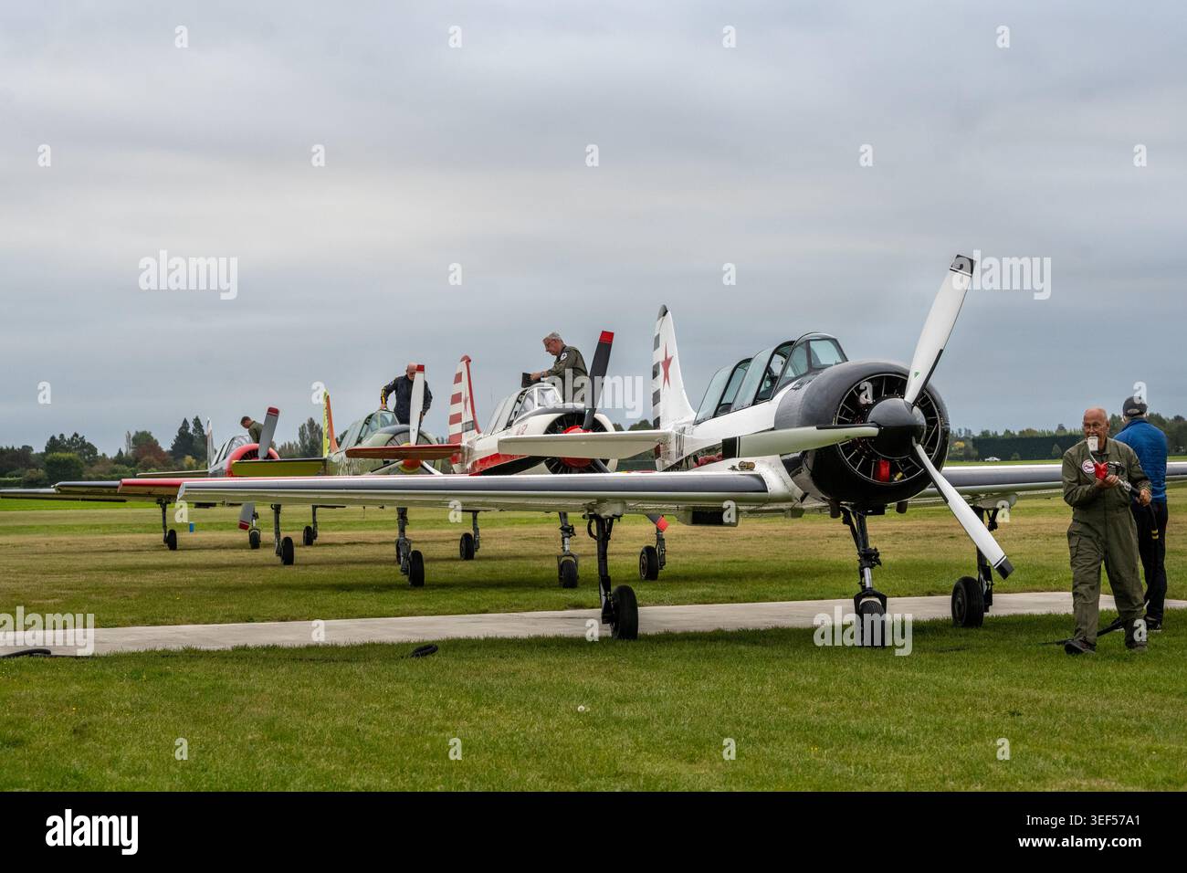 Aerei da guerra sovietiche in attesa di rifornimento. Una fila di membri della squadra di aerobatica Yakovlev Yak-52, Ashburton Airfield, Isola del Sud, Nuova Zelanda. Foto Stock